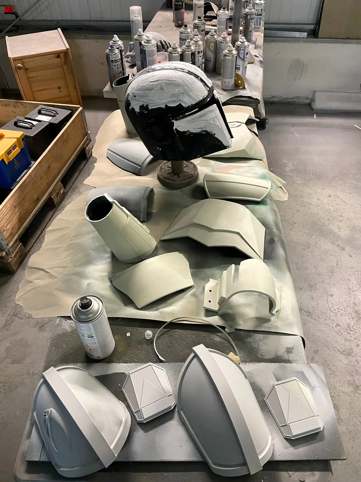Grundierte Rüstungsteile und Helm auf einem Tisch in der Werkstatt