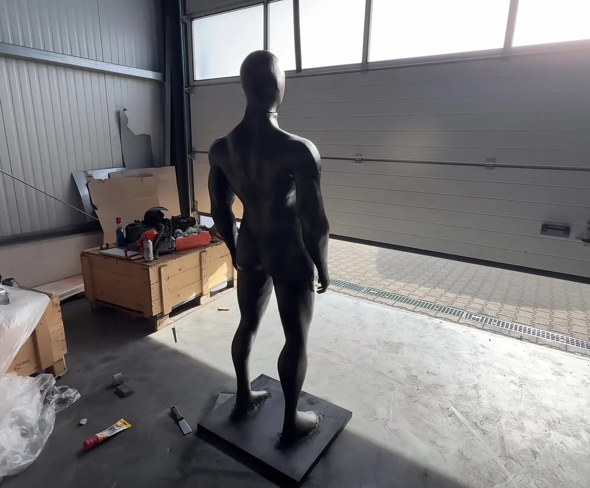 Figur von der Seite vor dem Hallentor